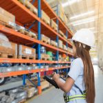 a female worker conducting a pallet racking inspection in London