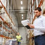 man in warehouse checking racking and load notices